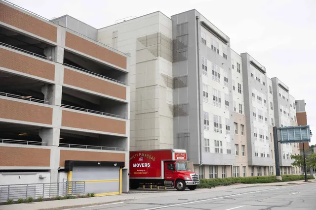 A red truck is parked in front of a building.