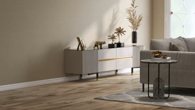 Modern living room featuring a sleek gray sideboard adorned with decorative items, including a bear figurine and plant, next to a stylish couch and round table.
