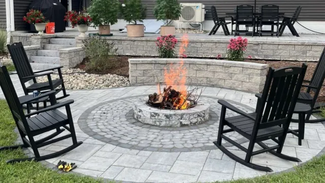 Flagstone patio at a CT home with brown adirondack chairs and a fire pit.
