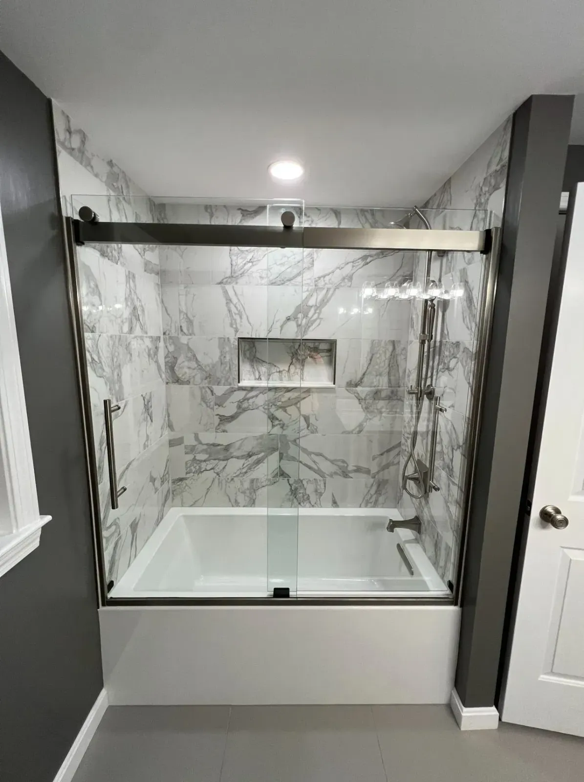 Modern bathroom with marble-tiled walk-in shower and glass enclosure