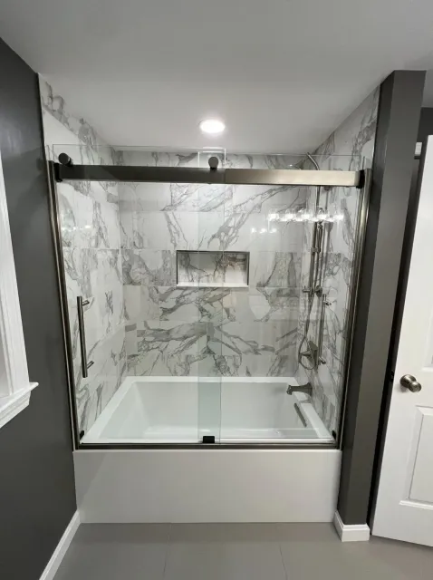 Modern bathroom with marble-tiled walk-in shower and glass enclosure