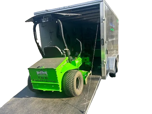 A electric stand-on mower driving into a trailer