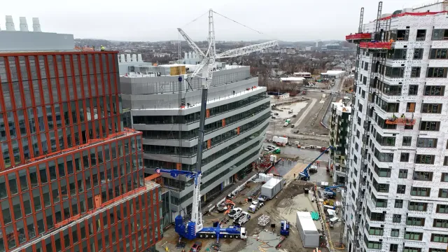 A CJ Shaughnessy crane working between mid-rise buildings on a job site