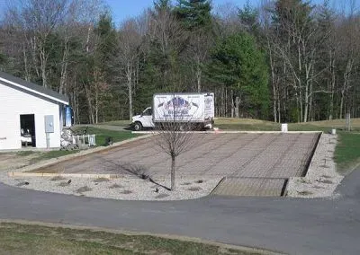 A white truck is parked in front of a building under construction.
