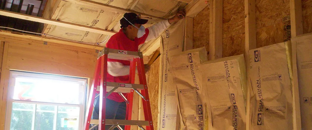 Fiberglass batt insulation installer