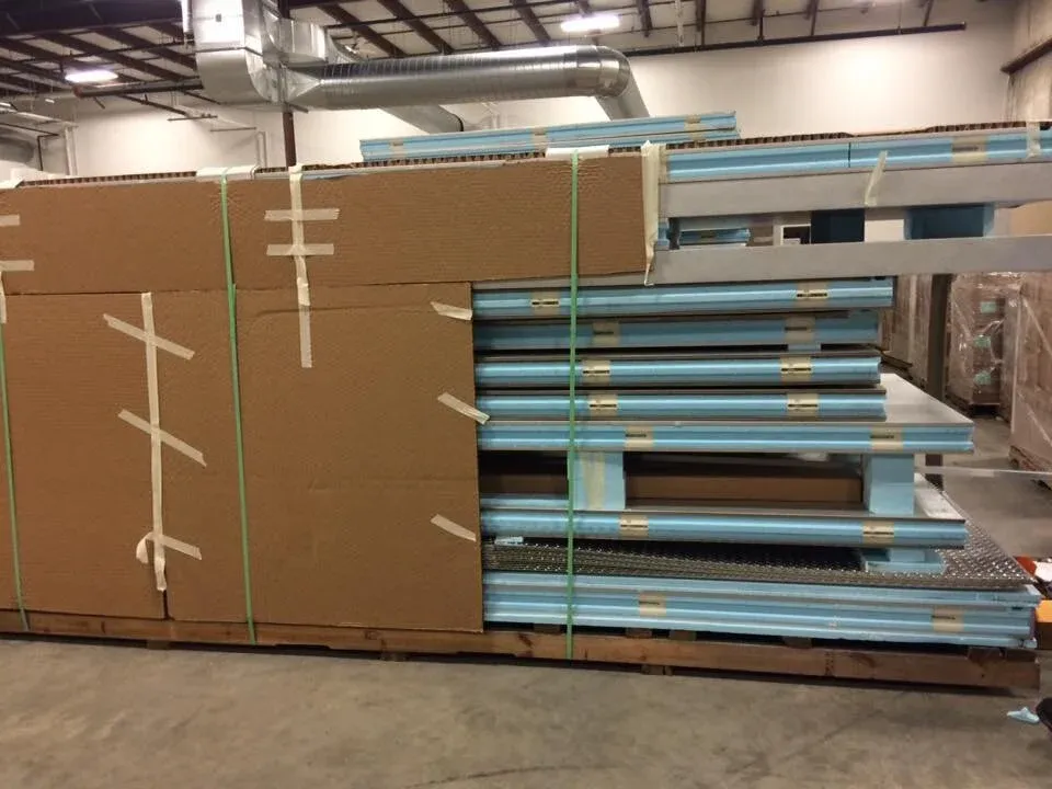 Stack of blue and brown insulated panels on a wooden pallet inside a warehouse.