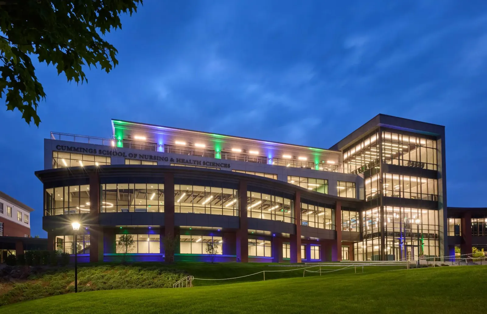 A large building with lots of windows is lit up at night.