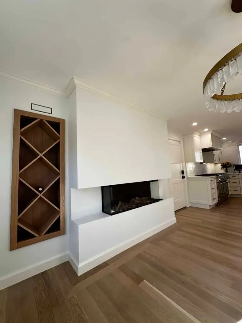 Modern living room with fireplace, built-in wine rack, and light wood flooring.