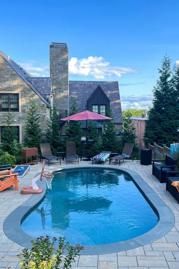 Organically shaped swimming pool with concrete unit paver deck