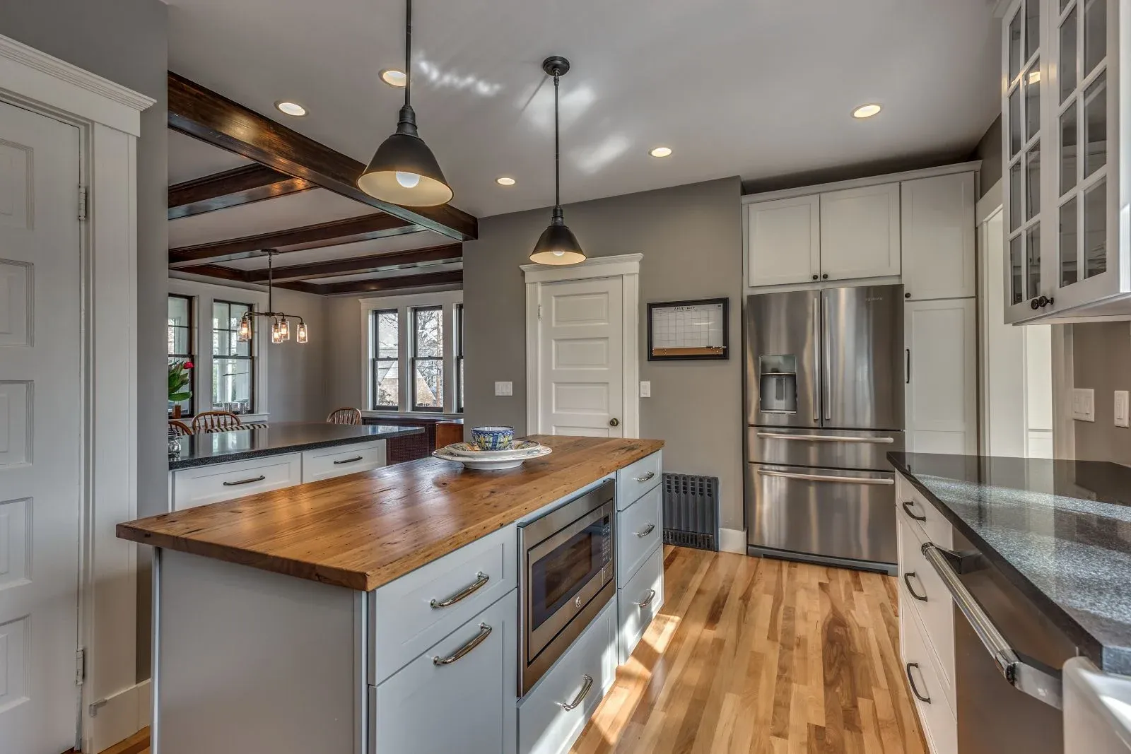 Kitchen renovation by PEGASUS Design-to-Build in Melrose MA featuring exposed beams, island seating, and white cabinetry-optimized