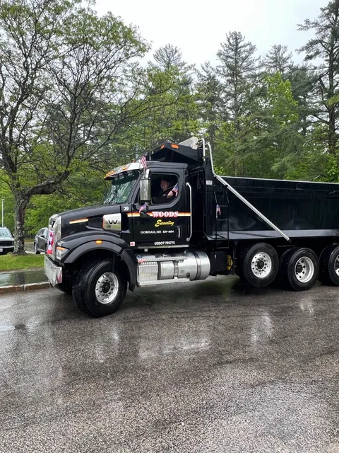Woods driver leaning out the cab with a flag, the lettered door and parade bunting on the grille