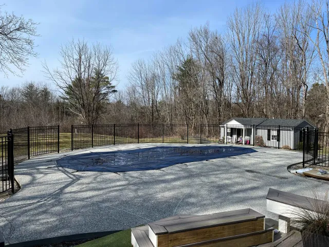 Olympic Fence Co. installing black pool fencing around a residential pool in the North Shore, MA.