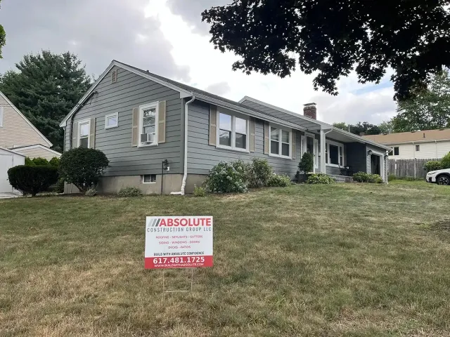 Completed siding job with the company's yard sign