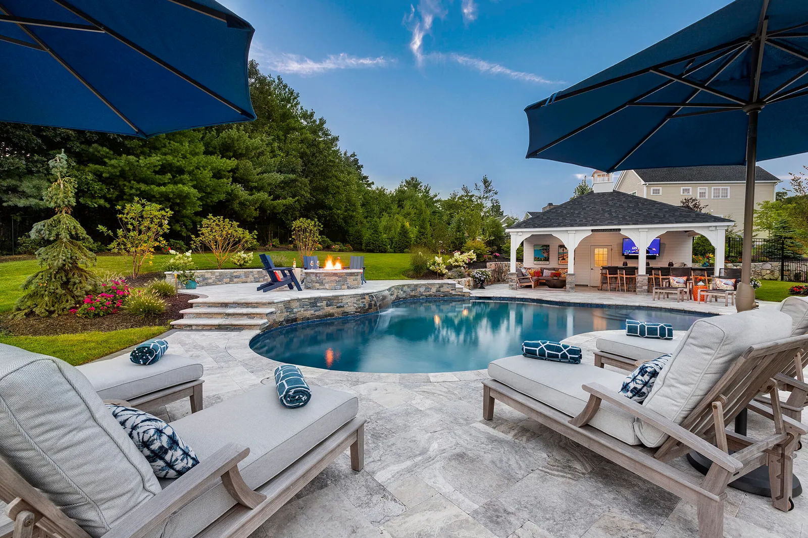 Landscape & Hardscape Design with pool deck, patio, and fire pit, built by Dex by Terra, at a home in Norfolk, MA.
