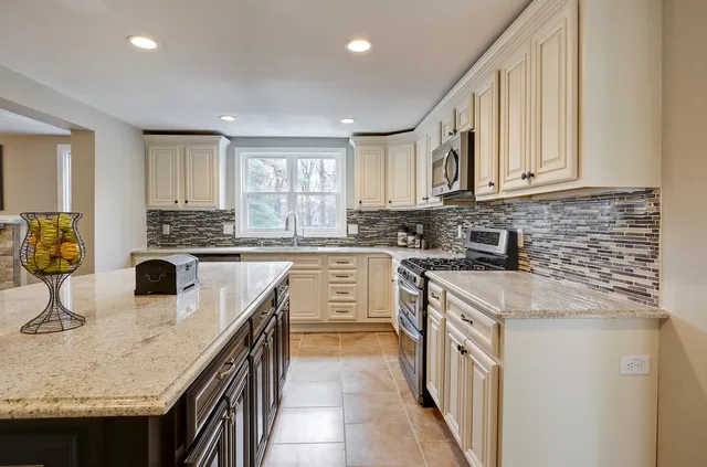 Finished kitchen with island and tile backsplash