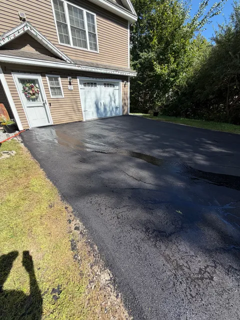 Freshly sealed driveway in front of a single-car garage
