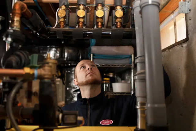 Quinoco technician servicing residential heating equipment to ensure efficient and reliable home heating.