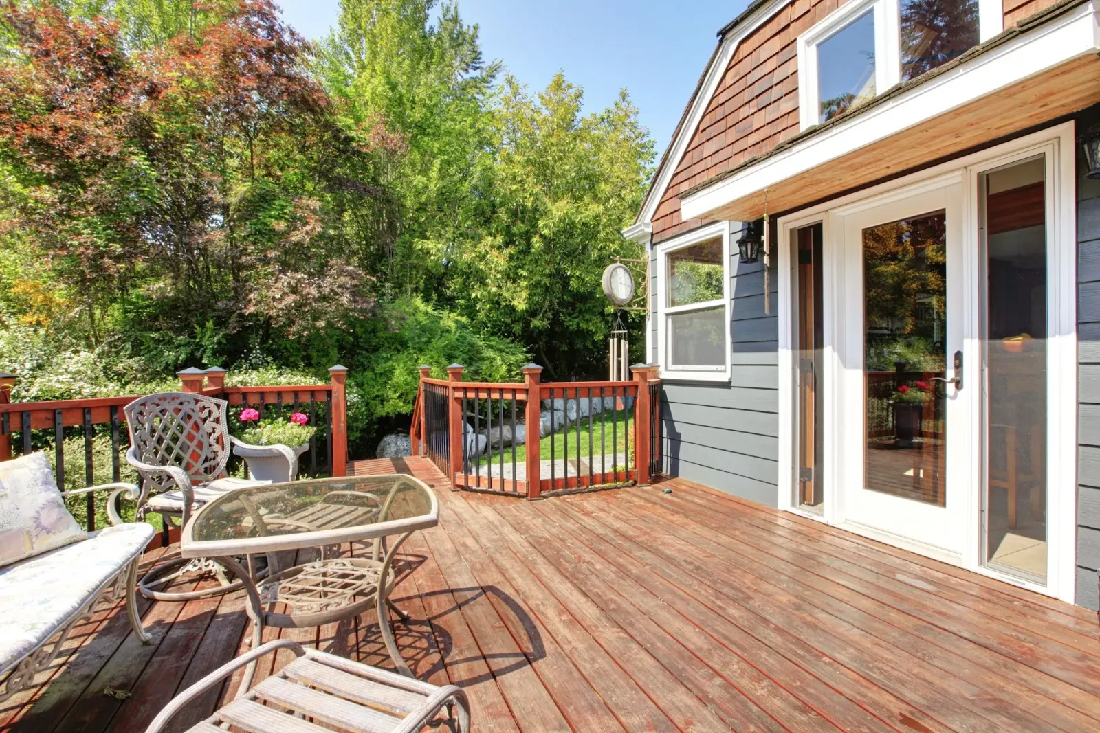 There is a large deck with a table and chairs on it.