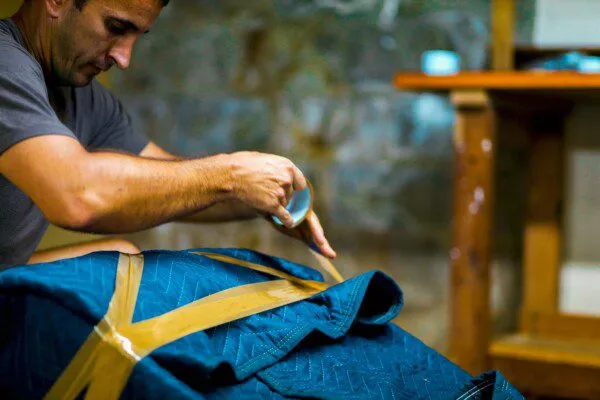 Boston mover wrapping furniture in padded wrap.