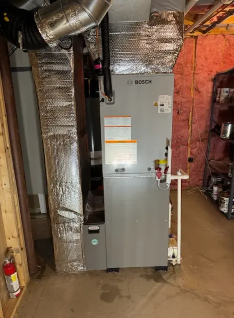 Bosch furnace in a basement setting with ductwork and fire extinguisher.