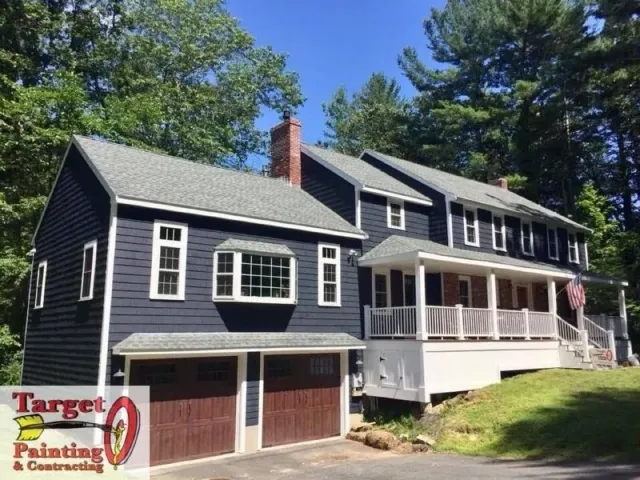 Deep navy colonial and attached garage after a full exterior repaint