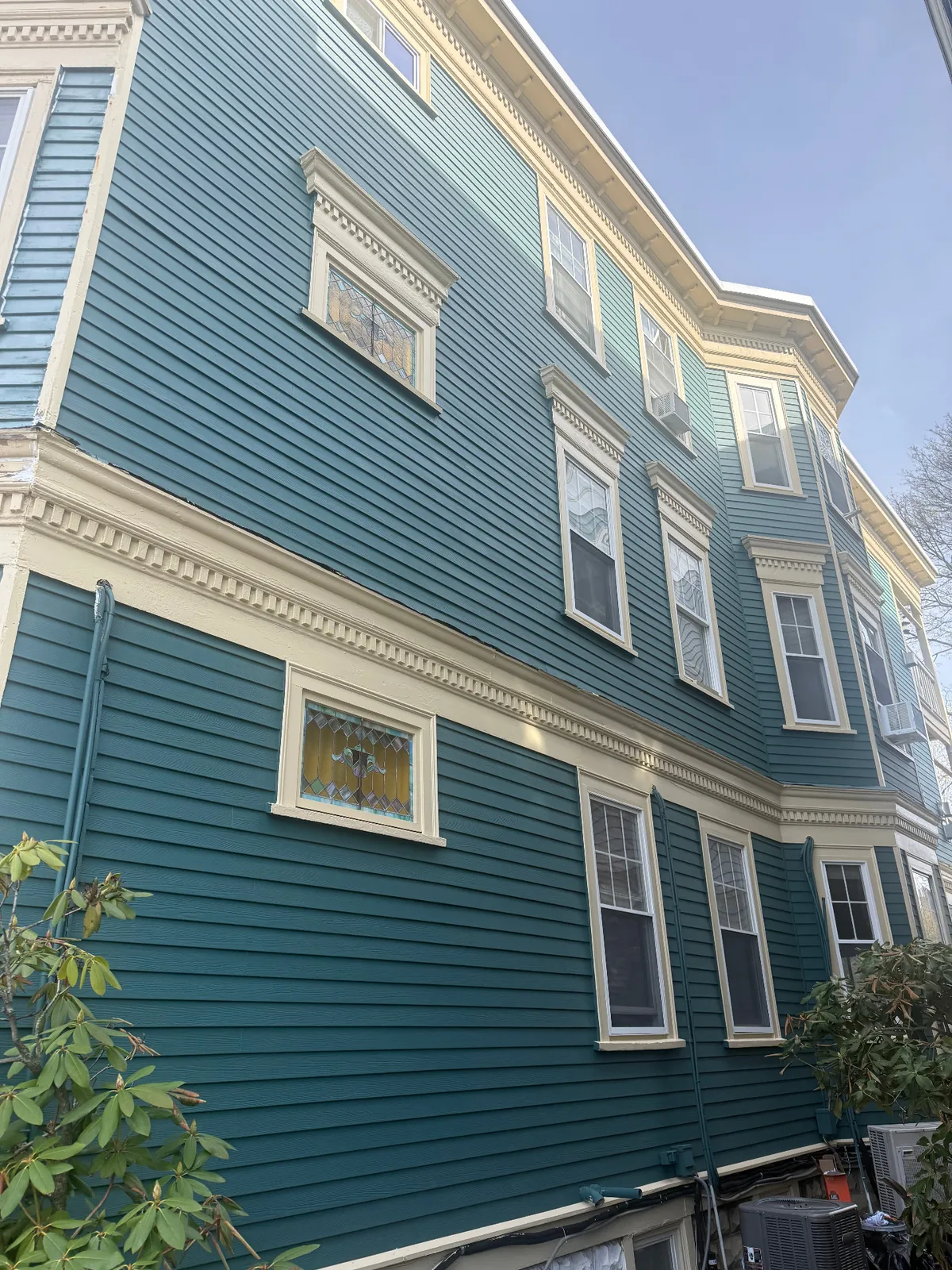 Finished teal Victorian multi-family exterior repaint with cream trim and dentil molding detail in Boston, MA