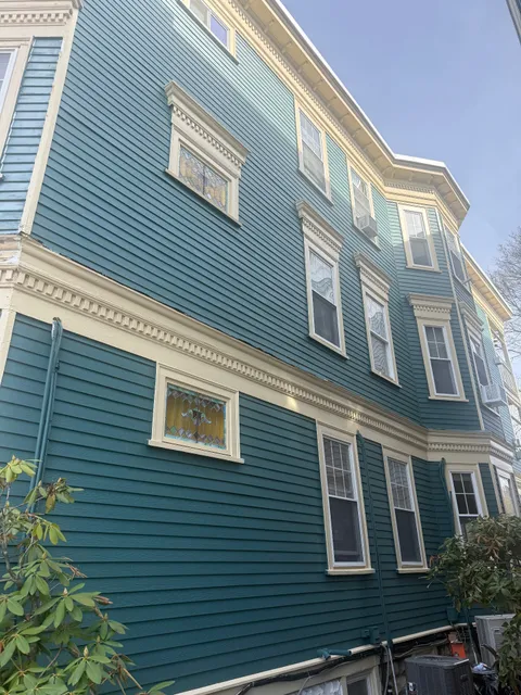 Finished teal Victorian multi-family exterior repaint with cream trim and dentil molding detail in Boston, MA