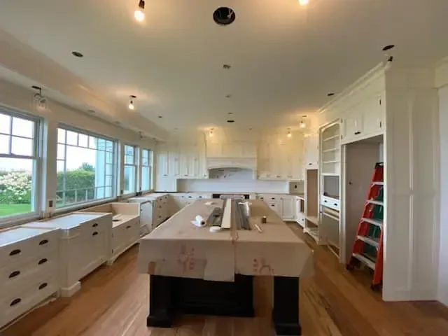A large kitchen with white cabinets and a large island
