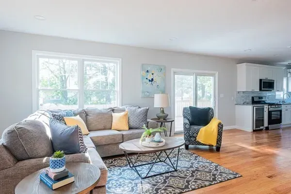 A living room with a couch , chair , coffee table and rug.