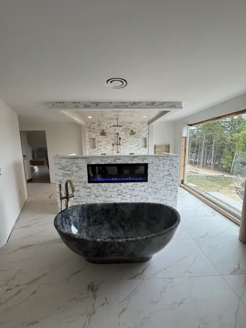 A bathroom with a large bathtub and a fireplace.