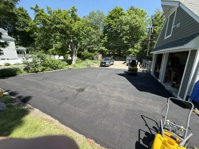 New asphalt driveway leading to a two-car garage at a Massachusetts home