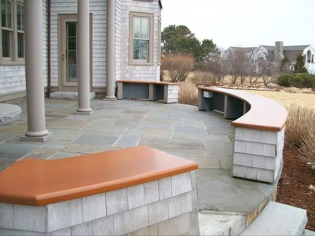 Mahogany-capped bench and wall caps on a shingle-style home patio