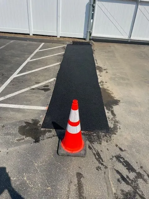 An orange and white traffic cone in a parking lot