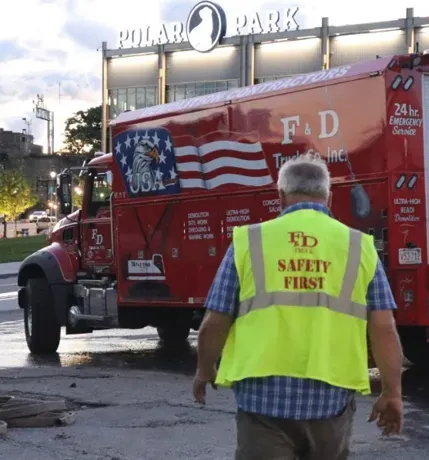 A man wearing a yellow vest that says fd safety first