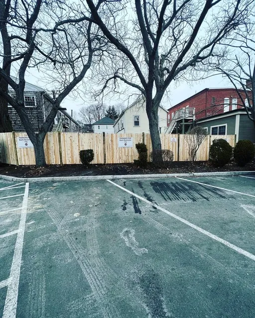 Completed cedar stockade fence enclosing a bank parking lot