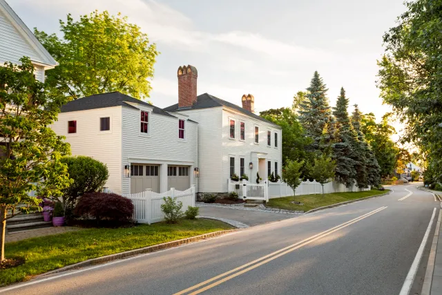White historic home and attached two-door garage viewed from the street