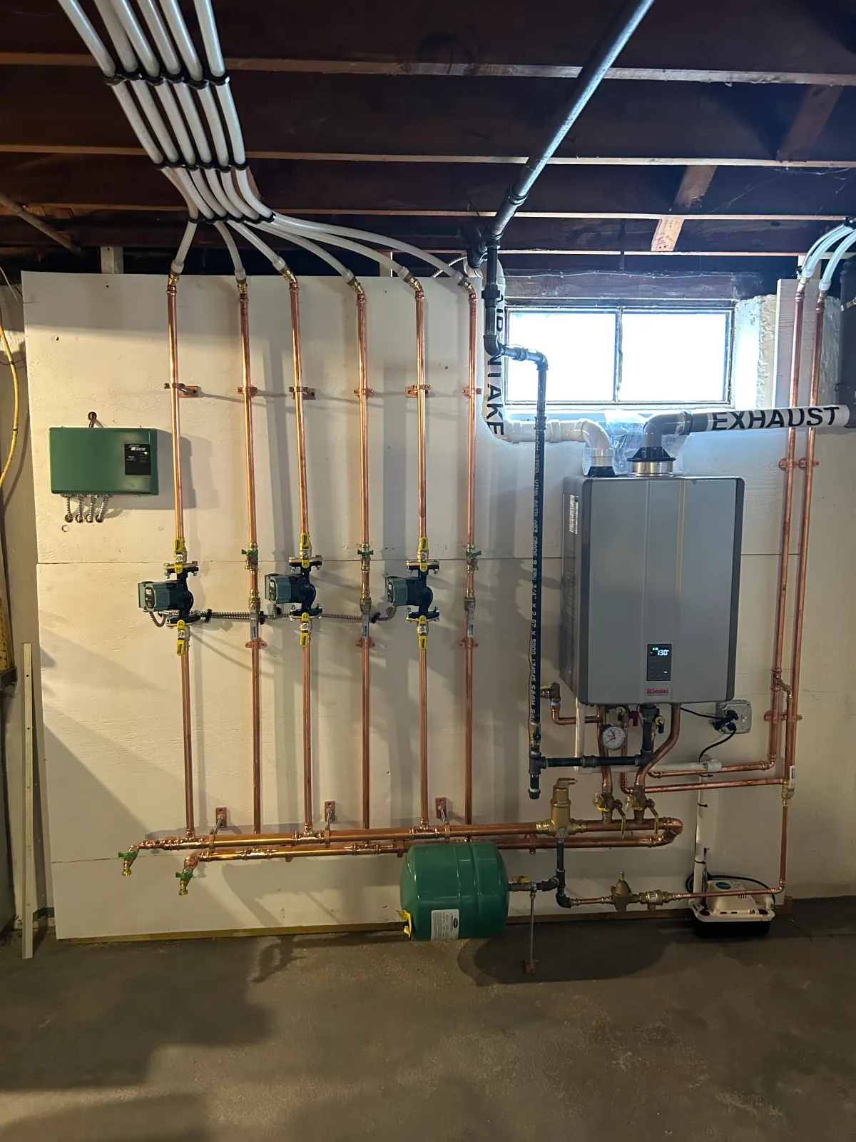 Commercial hydronic heating system with copper piping, tankless water heater, and expansion tank