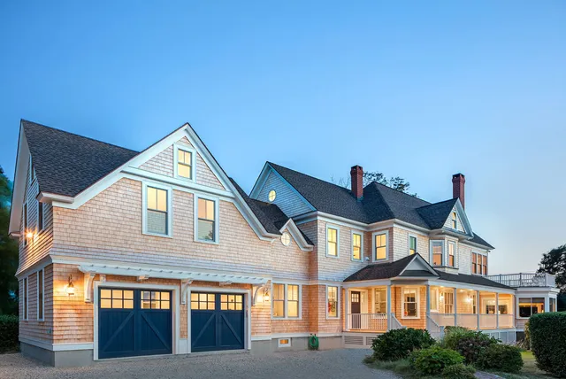 Large pink home with two-door garage and wraparound porch