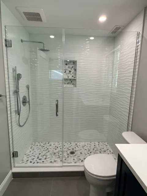 a bathroom with a walk-in shower, toilet, and sink
