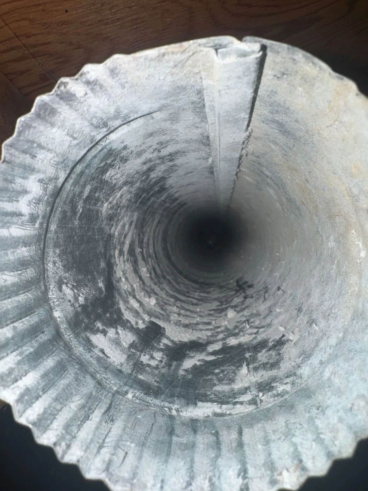 A cleaning brush passing through a dryer duct, with the walls behind it already clear of lint.