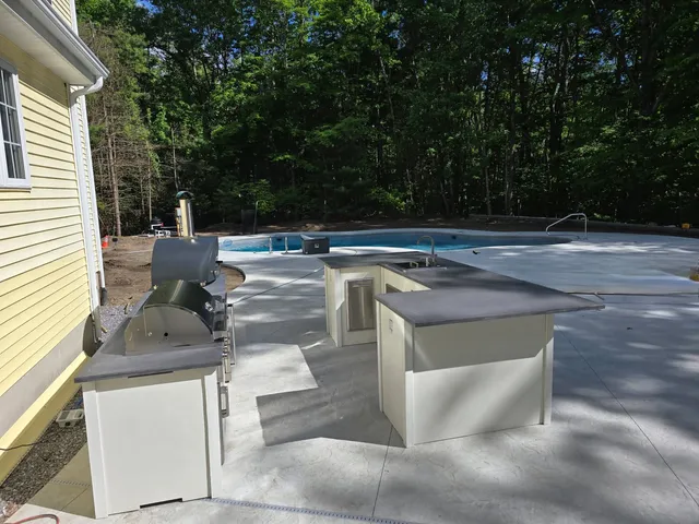 A white outdoor kitchen with an oven and sink.