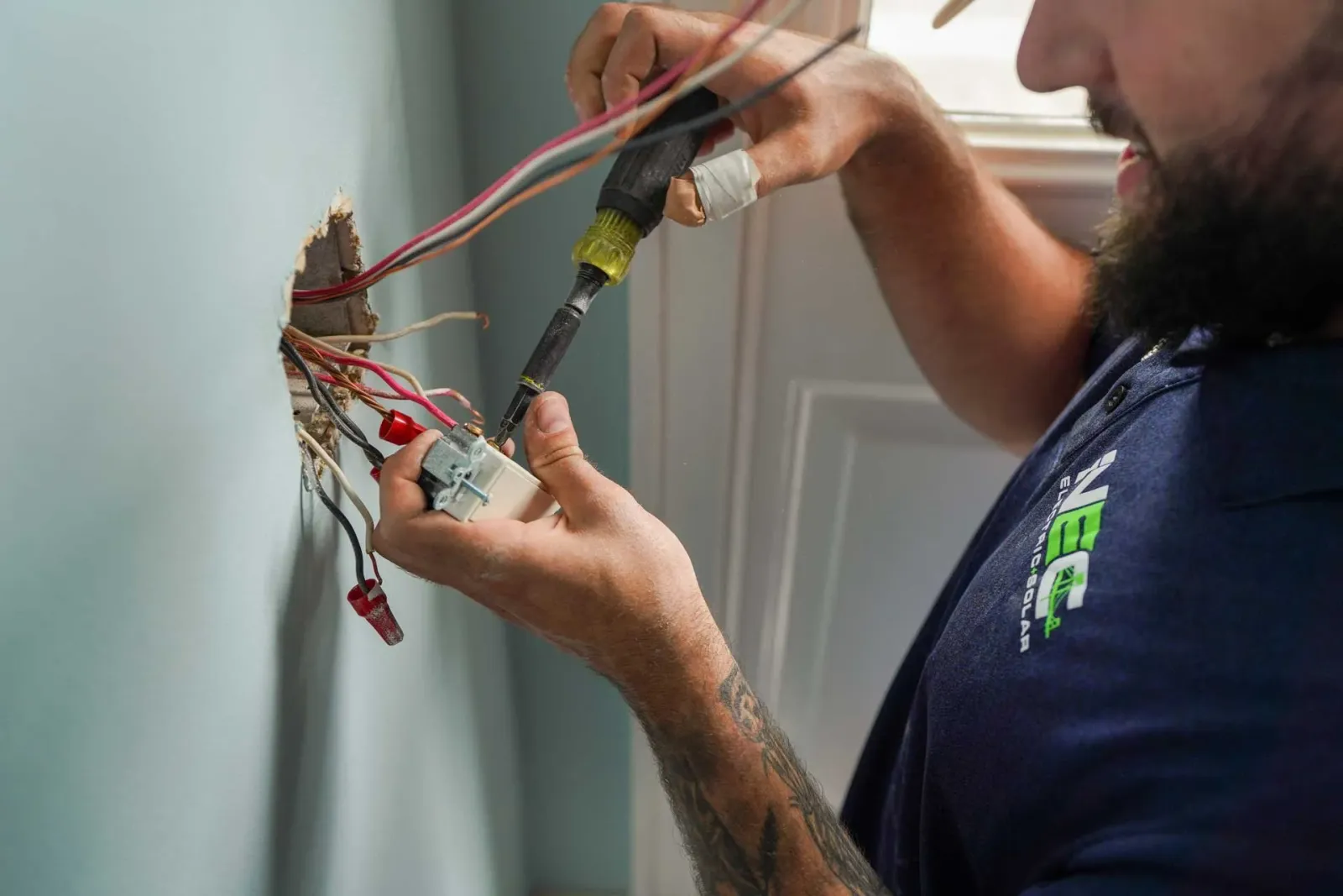 NEC technician wiring a receptacle on a service call