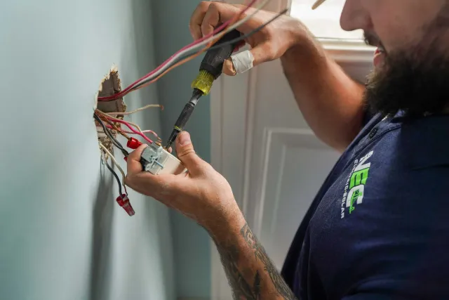 NEC technician wiring a receptacle on a service call