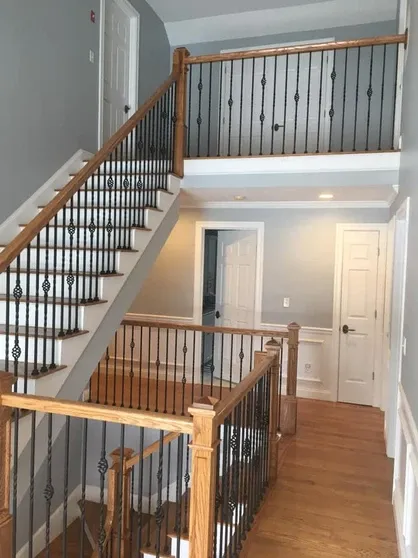 Multi-level staircase with wood steps and metal balusters