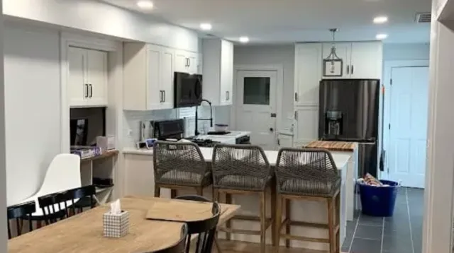 Modern white kitchen with dining area and bar seating, located in the Boston area