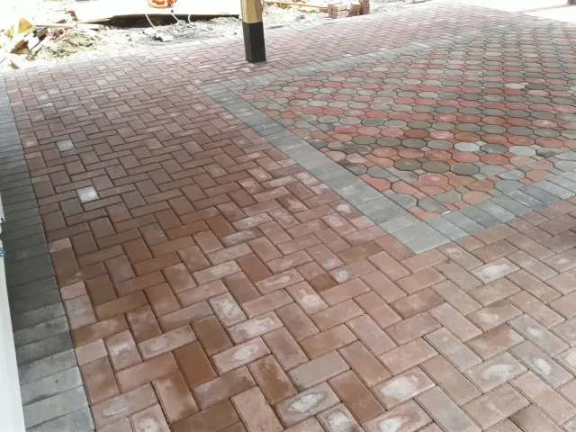Brick paver driveway laid in a herringbone pattern with a contrasting border
