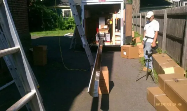 A man is standing in front of a truck filled with boxes
