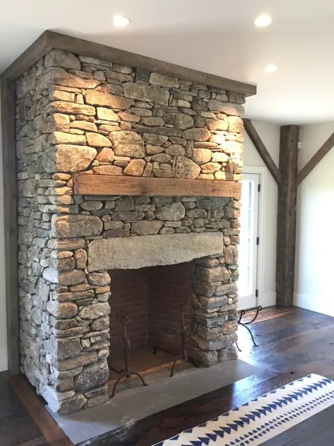 Interior flatwork construction on a fireplace featuring full size New England stone
