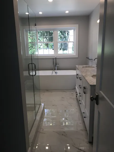 Bath with a freestanding soaking tub and glass shower