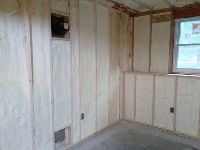 Spray foam wall insulation in a framed room corner in New Hampshire
